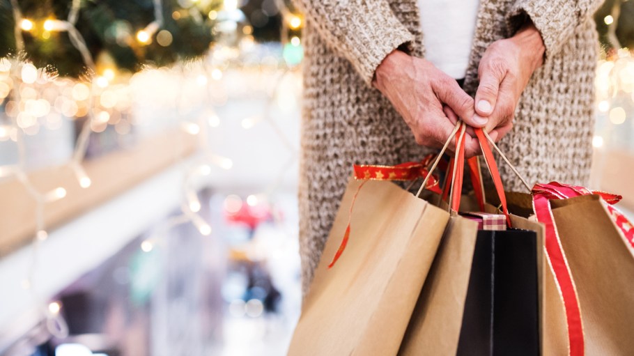 Unrecognizable senior woman with paper bags doing Christmas shopping.