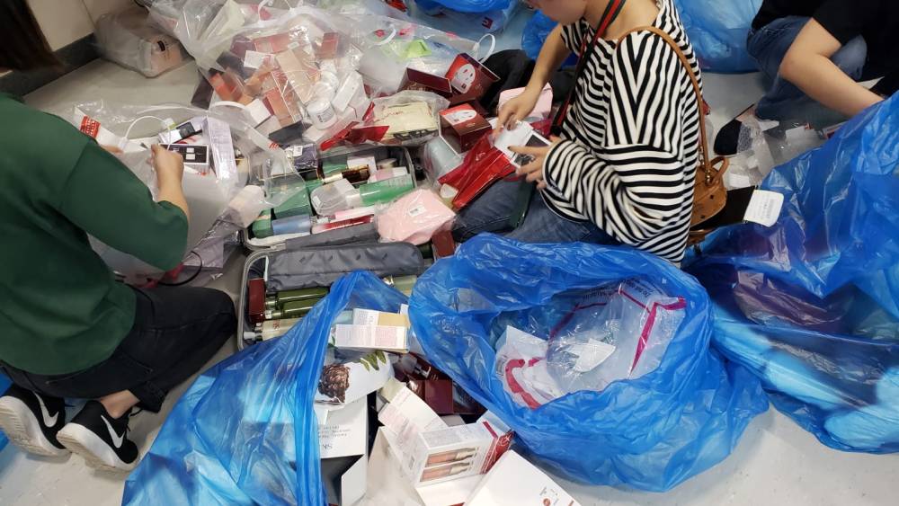 A gray market trader sorts through duty free purchases at Jeju airport.