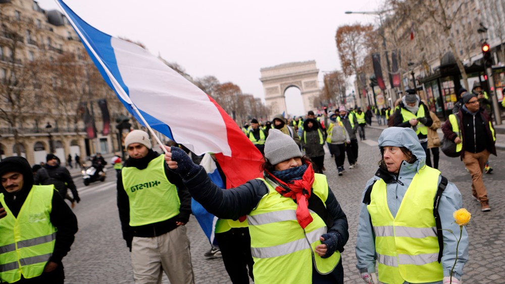 Demonstrators wearing yellow vests walk down the Champs-Elysees avenue, in Paris. A strong police presence has deployed in Paris before planned demonstrations by the "yellow vest" protesters, with authorities repeating calls for calm after previous violent protests and riotingProtests, Paris, France - 15 Dec 2018