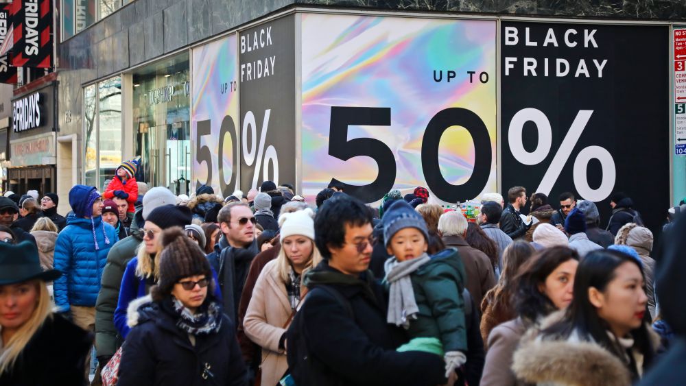 Crowds walk past a large store sign displaying a Black Friday discount in midtown Manhattan, in New York. The holiday shopping season presents a big test for a U.S. economy, with overall growth so far this year relying on a burst of consumer spendingHoliday Black Friday, New York, USA - 23 Nov 2018