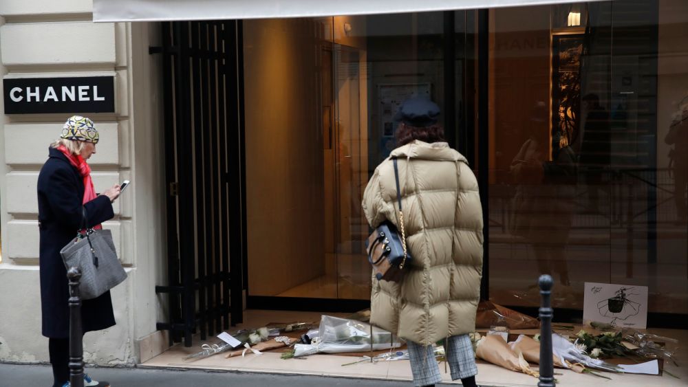 Women watch flowers at the entrance of Chanel headquarters in Paris, Wednesday, Feb.20, 2019. Karl Lagerfeld, the iconic couturier whose designs at Chanel and Fendi had an unprecedented impact on the entire fashion industry, died Tuesday in Paris, prompting an outpouring of love and admiration for the man whose career spanned six decadesObit Lagerfeld, Paris, France - 20 Feb 2019