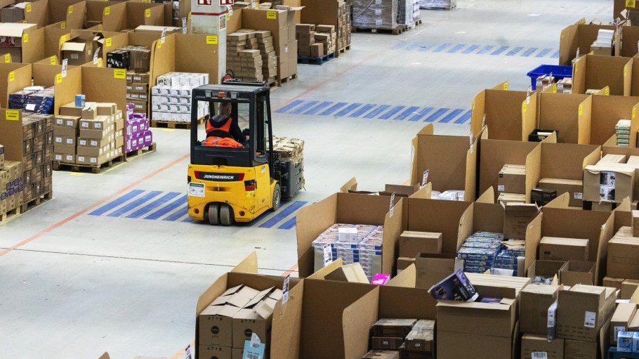 An employee uses a forklift truck to move boxes around an Amazon.com Inc. fulfilment center in Koblenz, Germany