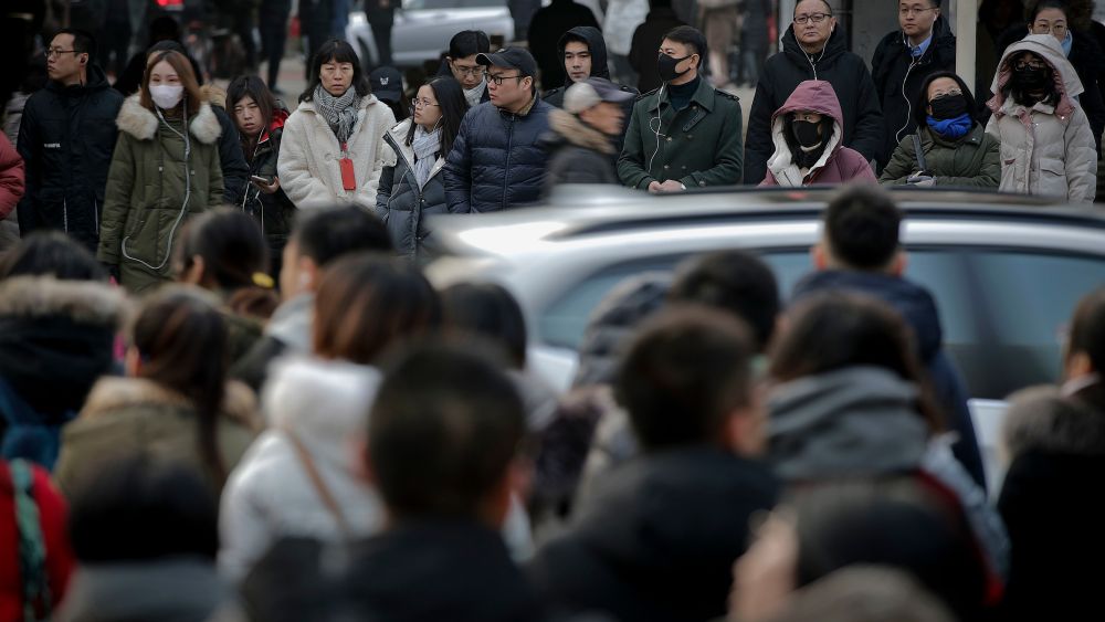 Pedestrians wait to cross a traffic intersection at the Central Business District in Beijing, . China's 2018 trade surplus with the United States surged to a record $323.3 billion but exports contracted in December as the delayed impact of President Donald Trump's tariff hikes started to depress demand. Global exports shrank 4.5 percent in December, reflecting weak consumer demandTrade, Beijing, China - 14 Jan 2019