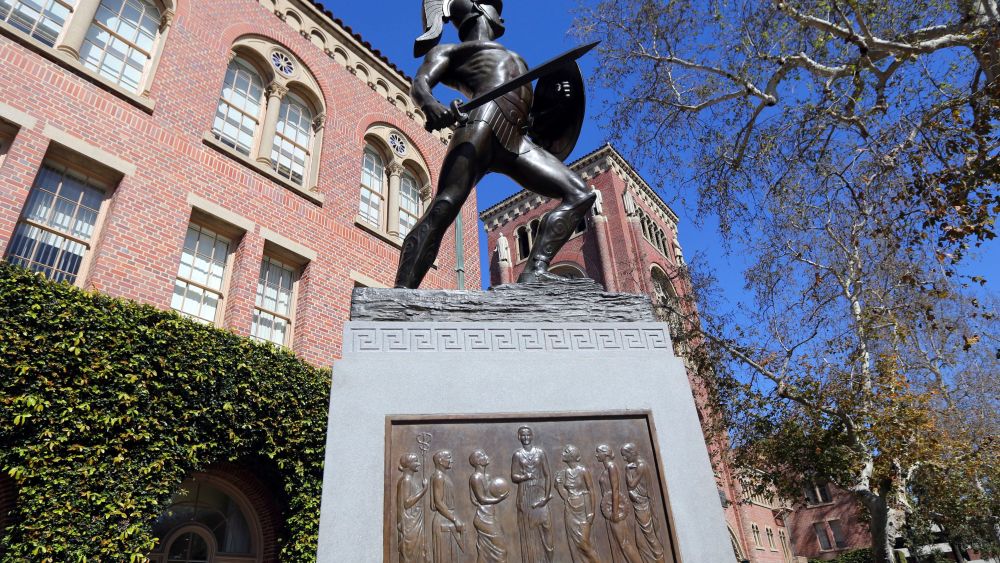 This photo shows the iconic Tommy Trojan statue at the University of Southern California in Los Angeles. USC is one of many colleges and companies moving swiftly to distance themselves from employees swept up in a nationwide college admissions scheme, many charged with taking bribes and others from well-to-do and celebrity parents accused of angling to get their children into top schools. By Wednesday, March 13, USC had fired senior associate athletic director Donna Heinel and water polo coach Jovan Vavic. USC's interim President Wanda Austin said about a half-dozen current applicants affiliated with Singer's firm will be barred from admission. (AP Photo/Reed Saxon)may be connected to the scheme alleged by the governmentCollege Admissions Bribery, Los Angeles, USA - 12 Mar 2019
