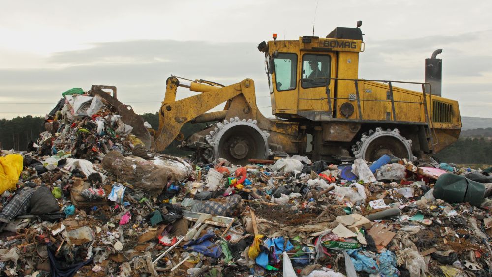 Compactor moving rubbish on landfill tip, Dorset, England, FebruaryNature