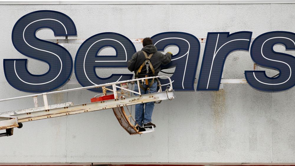 In this Feb. 13, 2012 photo, a worker repairs the Sears sign outside the Sears Grand store in Solon, Ohio. Sears Holdings said, it will separate its smaller hometown stores, outlets and some hardware stores in a deal expected to raise $400 million to $500 million as it seeks to regain profitability and market shareEarns Sears, Solon, USA