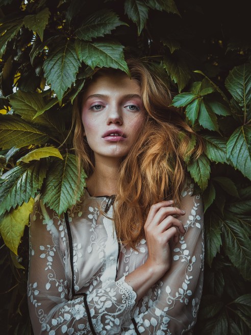 girl in a dress surrounded by leaves for green fashion