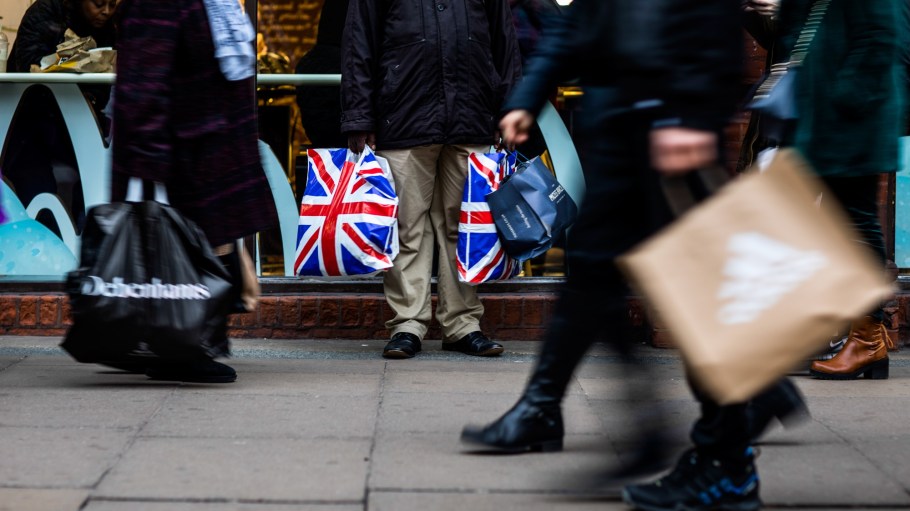 A pedestrian holds shopping bags branded with the Union Flag, also know as Union Jack, on Oxford Street in central London, U.K., on Tuesday, Dec. 4, 2018.