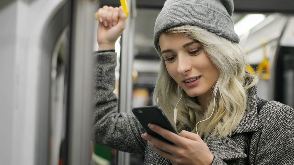 Young teenage girl using her cell phone in public transportation