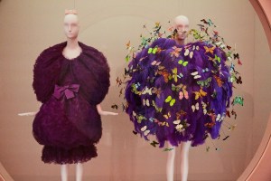 A Cristóbal Balenciaga evening ensemble from fall 1961 and a fall 2018 one from Jeremy Scott for Moschino embroidered with purple ostrich feathers, and polychrome printed feather and paper butterflies.