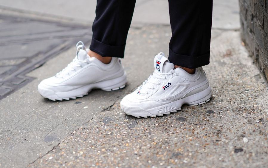 A guest wears white FILA sneakers shoes, during London Fashion Week Men's