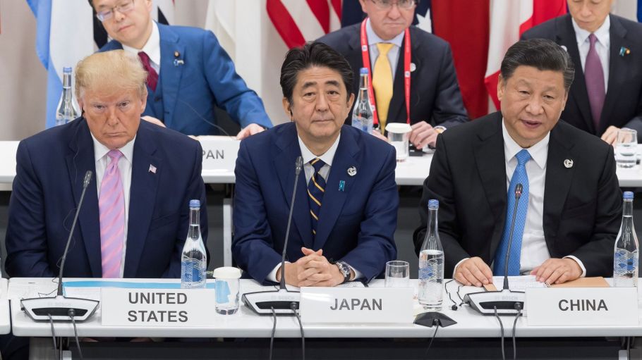 US President Donald Trump (L) sits with Japan's Prime Minister Shinzo Abe (C) and China's President Xi Jinping as they attend a meeting on the digital economy at the G20 Summit in Osaka on June 28, 2019.