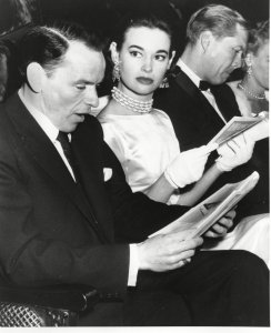 Gloria Vanderbilt seated next to singer Frank Sinatra at the Alvin Theater in New York in 1954