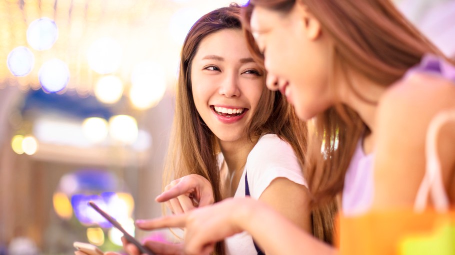 happy girls watching phone in the shopping mall