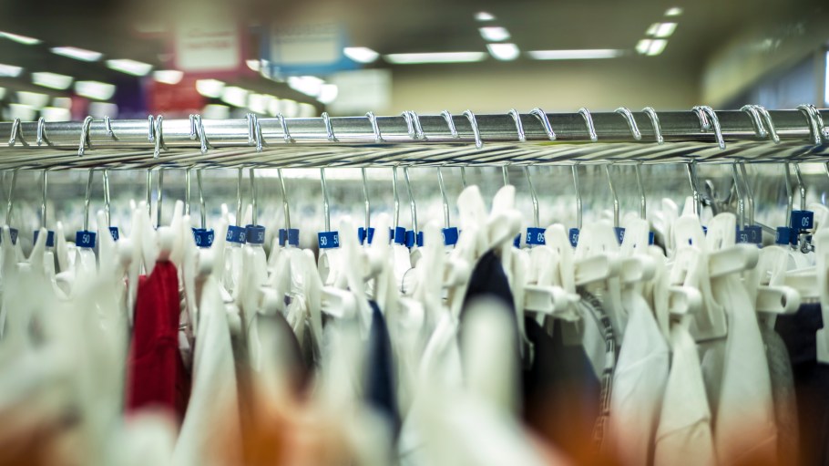 close up store shelves and row with hanging clothes in the shop