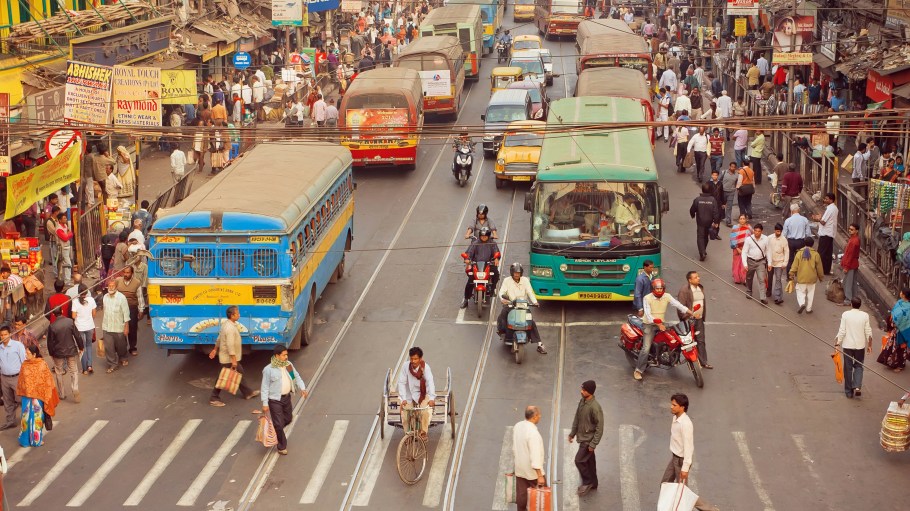 Crossroad of busy modern city in Asia with cars, bikes, walking people and buses on January 20, 2016 in Calcutta.