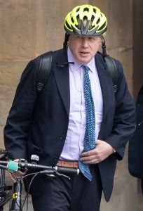 Boris Johnson stands with his bicycle as he arrives in Parliament