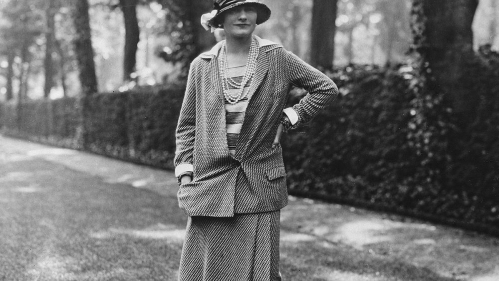 French fashion designer Coco Chanel (1883-1971) wearing a design of her own creation poses in a garden on the Rue du Faubourg Saint-Honore, Paris, France, 30th May 1929. Chanel owned an apartment on the rue du Faubourg Saint-Honore. (Photo by Sasha/Evening Standard/Hulton Archive/Getty Images)