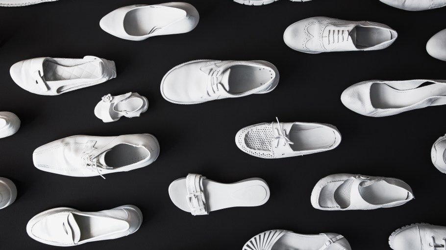 Many different white shoes on a black background