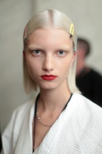 "There is a bit of a Donna Summer feel, there is a bit of a Grace Jones feel, there is a little bit of a nod to beauty in the Eighties, but the makeup overall has a little bit more of a relaxed fit," said Chantel Miller, senior national artist for MAC. Skin was evened out with Studio Fix Stick Foundation, paired with either about six layers of liquid lipstick for a graphic red lip, or a flick of forest green liquid eye lacquered liner. "It actually points downÉit means as the girls walk in the show in profile, the liner looks exactly straight," Miller said. Other models had MAC's Glow Play blushes brushed up through the temple, onto the brow bone. Ñ Allison Collins