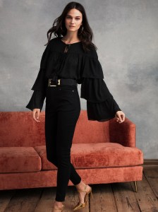 A black blouse with dramatic sleeve action.