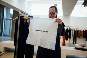 The designer showing an embroidered handkercheif he received from an L.A. friend.