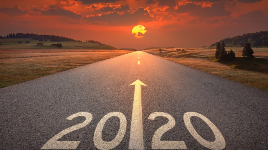 Driving on idyllic open road against the setting sun forward to upcoming 2020 new year.