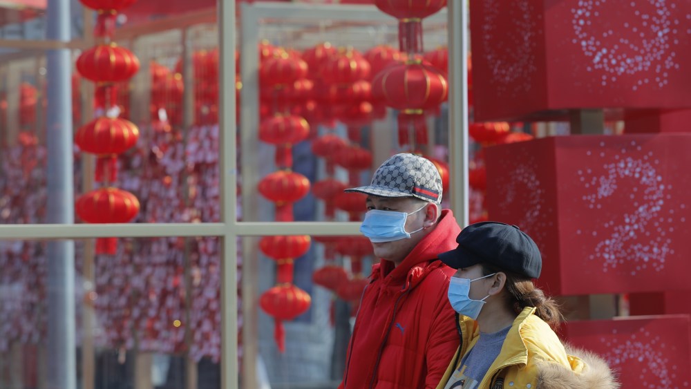 Chinese people wear masks in a street of Beijing, China.