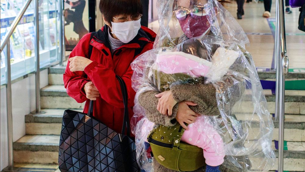 A woman with her child wrapped in a plastic sheet in Hong Kong.