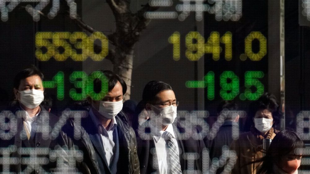 Pedestrians wearing masks are reflected in a stock market indicator display board in Tokyo, Japan, 03 February 2020. The 225-issue Nikkei Stock average hit a three-month low during the morning trading session, following rising concerns over the impact of the novel coronavirus' impact on the global.Stocks fall as coronavirus concerns escalate, in Tokyo, Japan - 03 Feb 2020