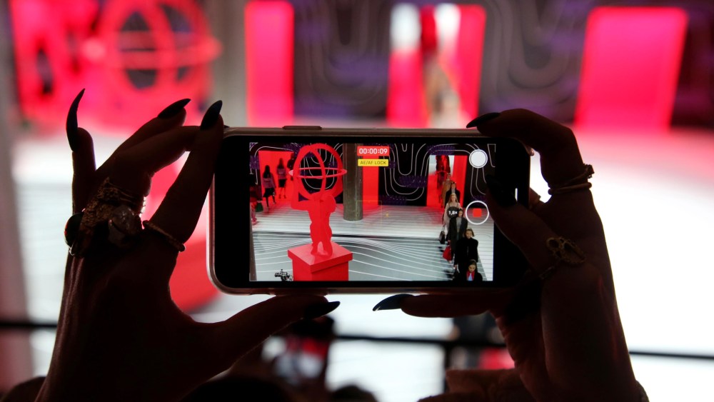 A member of the audience takes a photo with a smartphone during the Prada show at the Milan Fashion Week, in Milan, Italy, 20 February 2020. The Fall-Winter 2020 Women's collections are presented at the Milano Moda Donna from 18 to 24 February 2020.Prada - Runway - Milan Fashion Week Women's F/W 2020/21, Italy - 20 Feb 2020