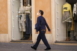 Man walks by closed boutiques in Rome, Italy.
