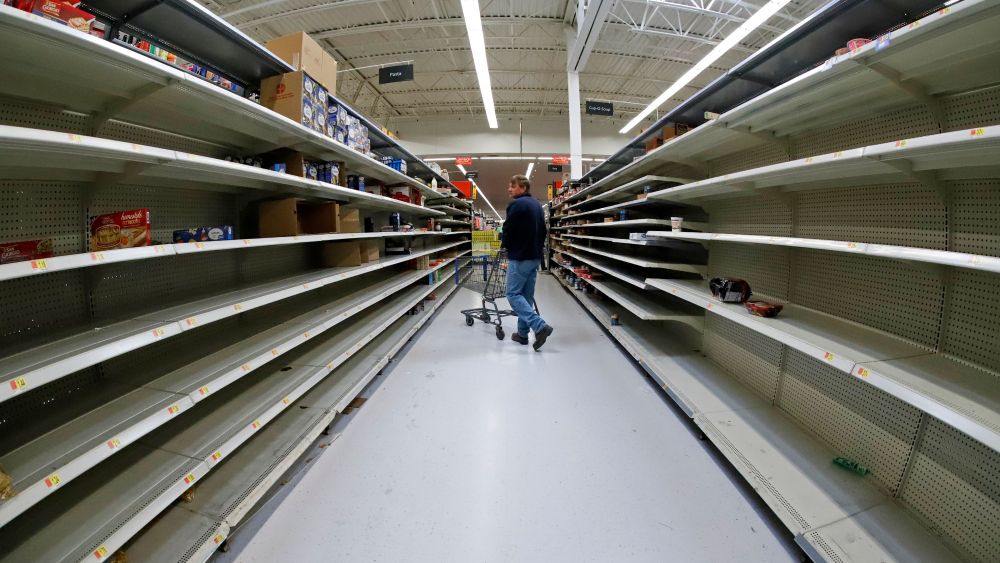 Man shops in an aisle of mostly empty shelves in a Walmart in Cranberry Township, Pennsylvania.