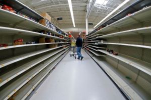 Man shops in an aisle of mostly empty shelves in a Walmart in Cranberry Township, Pennsylvania.