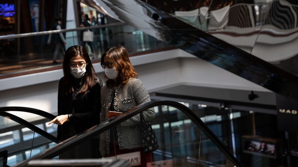 People wear face masks at a shopping mall in Hong Kong,