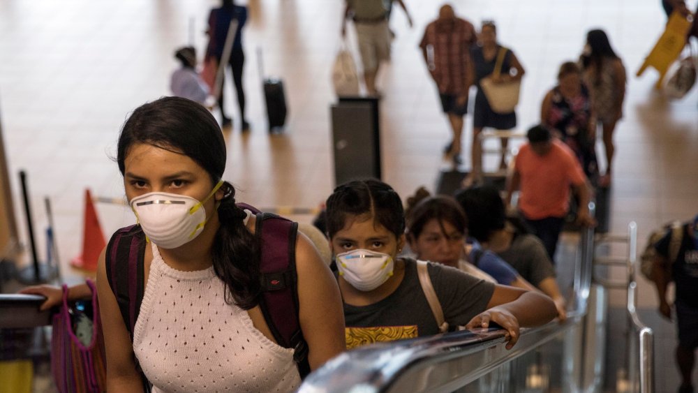 Travelers wearing protective masks in Lima.