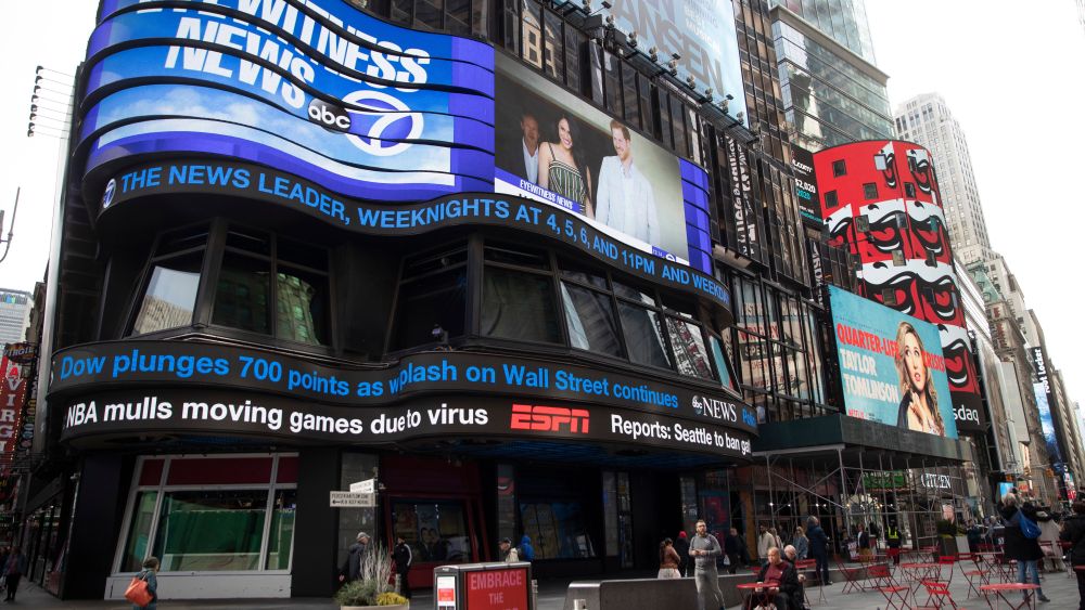 The ABC News ticker displays news on the financial markets and the possibility of the NBA moving games due to the coronavirus, in New York's Times Square. New York Gov. Andrew Cuomo said Wednesday he will ask business owners to stagger their employees' work shifts or let them work from home to reduce potential coronavirus exposuresVirus Outbreak , New York, United States - 11 Mar 2020