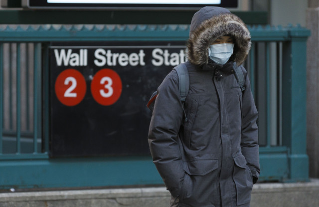 A person in a protective mask walks past the Wall Street subway station near the New York Stock Exchange in New York, New York, USA, 16 March 2020. Stocks opened sharply lower this morning and trading was halted for 15 minutes at the opening bell as investors continue to react to the impact of the coronavirus COVID-19 pandemic.New York Stock Exchange Coronaviurus reaction, USA - 16 Mar 2020