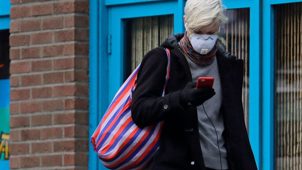 woman in mask with phone coronavirus Seattle
