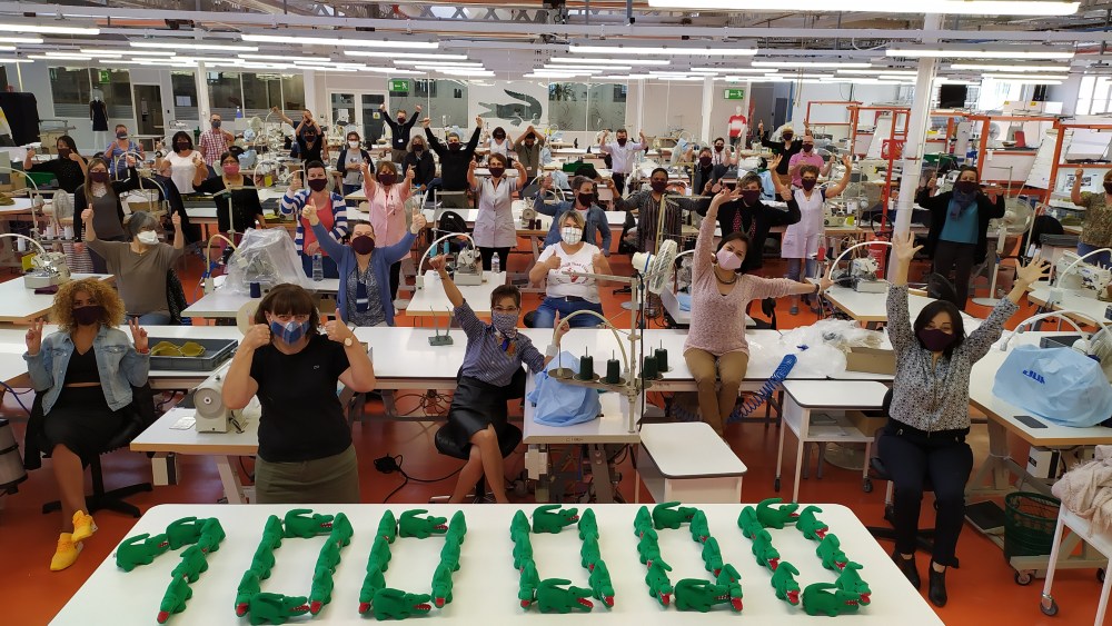 Workers cheering at the Lacoste factory in Troyes, France