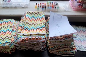 Fabric masks are not medical-grade but are rather intended for frontline essential workers, such as food delivery or grocery clerks.  Here are stacks of fabric masks, completed by Howe.