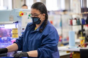New Balance associate using and fabricating face masks at the company’s Lawrence, MA factory.