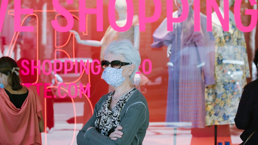 A shopper waits for the doors to open at the Galeries Lafayette flagship on Boulevard Haussmann in Paris.