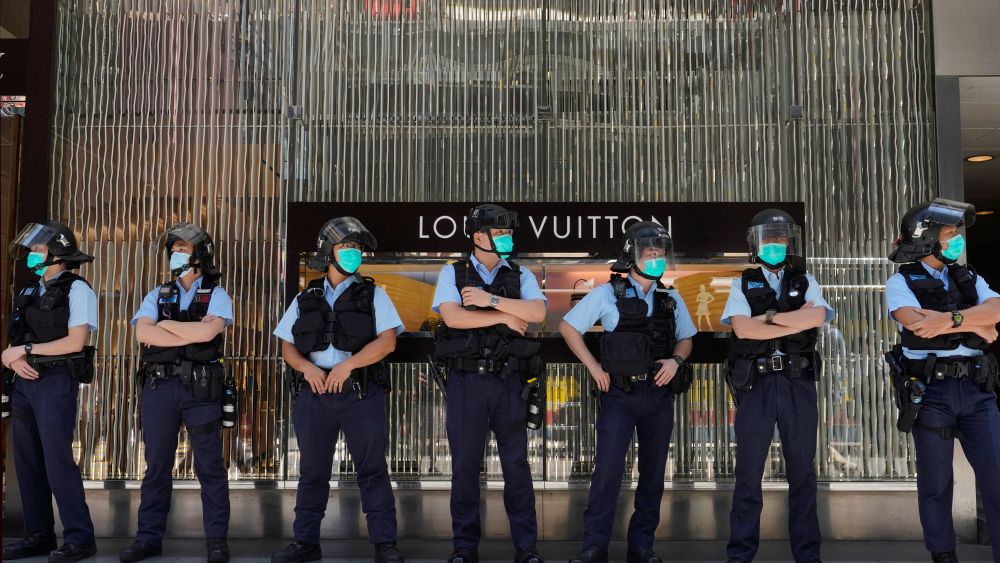 Police officers stand guard during a protest outside a luxury shopping mall Hong Kong.