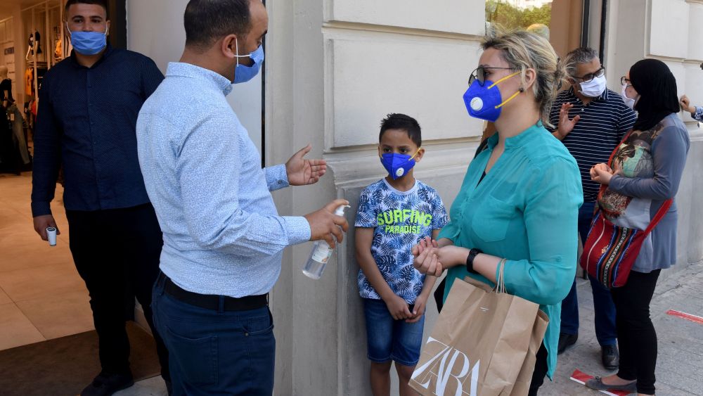 An employee sprays some alcoholic gel on customers' hands outside a fashion shop in Tunis, Monday, May, 11, 2020. Fashion shops reopen Monday in Tunisia allowing citizens to buy new outfits to celebrate the Aid next weekVirus Outbreak , Tunis, Tunisia - 11 May 2020
