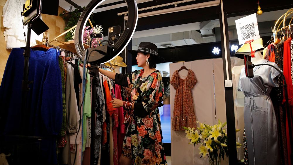 A Beijing shop owner prepares racks of clothes for a livestream.