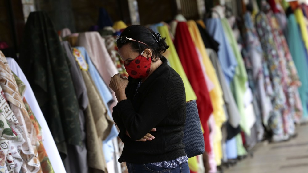A woman browses at an apparel and textiles market.