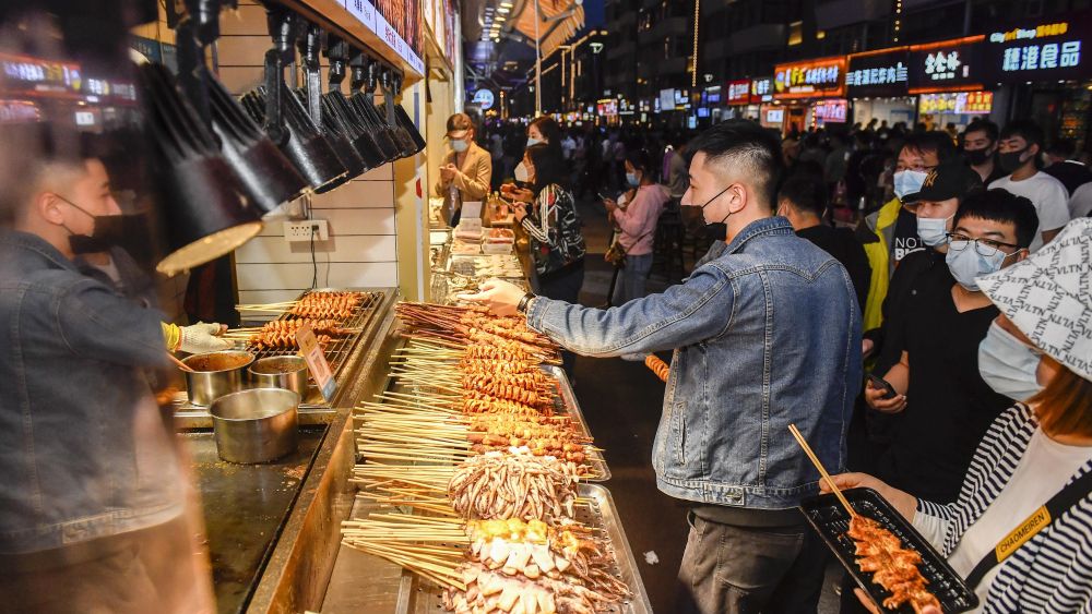 People buy snacks at a commercial street in Changchun, northeast China's Jilin Province.