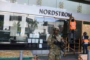 Nordstrom in Santa Monica under the watch of National Guard as its boarded up Monday.