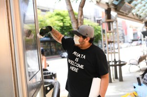 A man helps to clean off graffiti put on a Santa Monica business the night before.